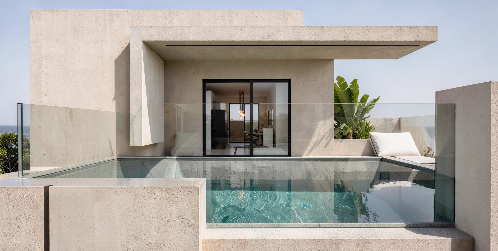 Travertine façade with the elevated pool and cantilevered roof at golden hour.